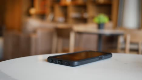 person using smartphone in a cafe