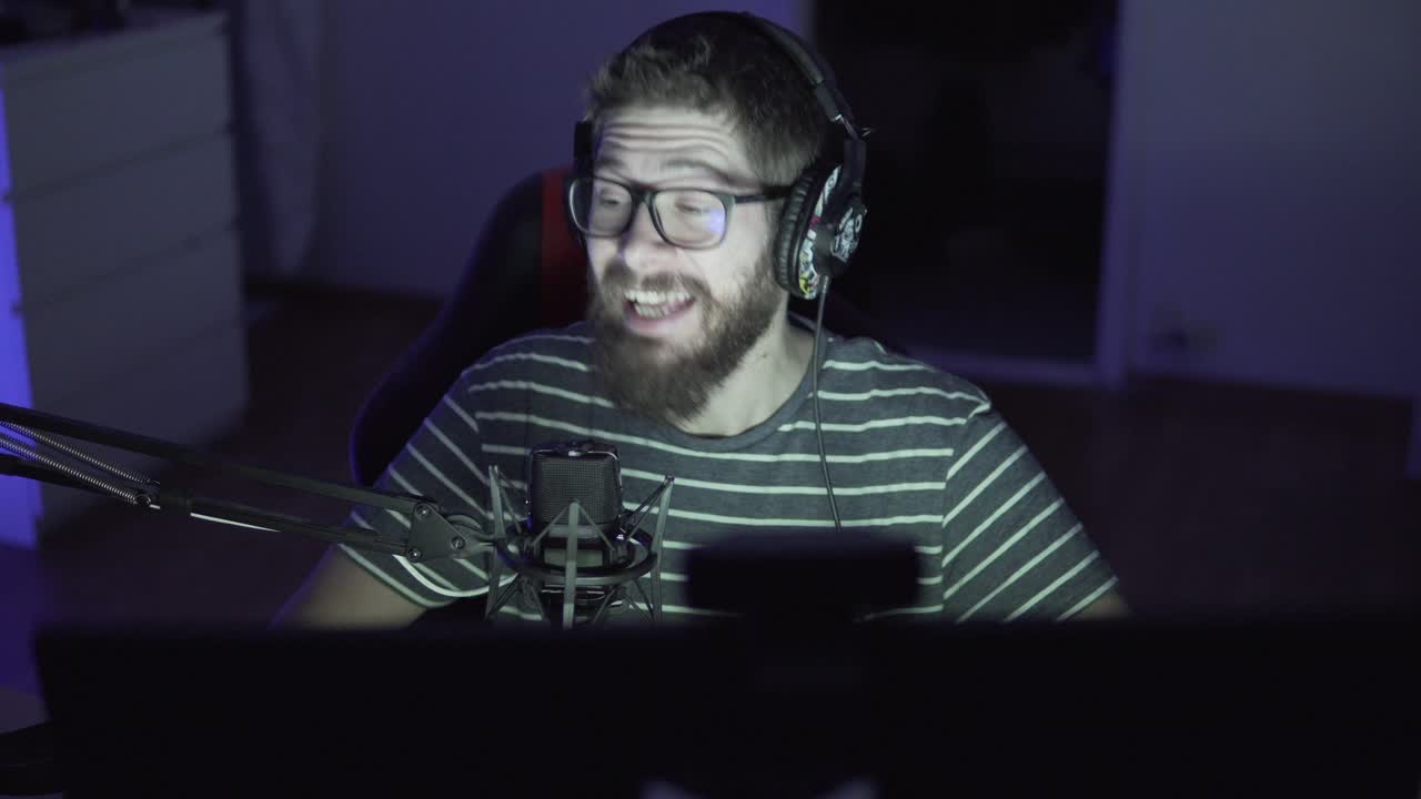 streamer de mediana edad está jugando juegos chateando con los espectadores por la noche
