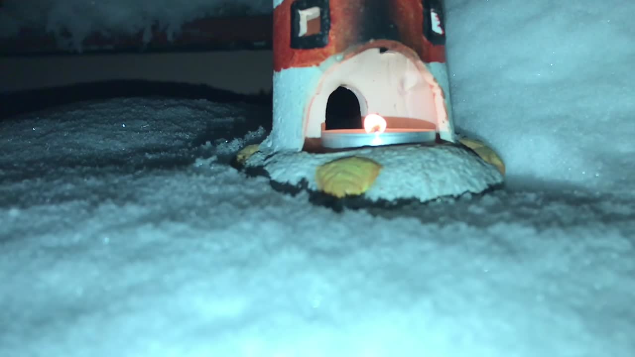 Approaching a lighthouse in massive snow at night with tea candle light