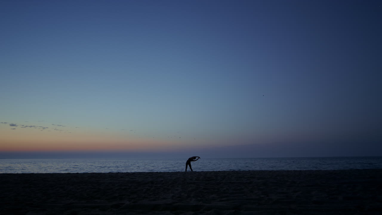 해가 지면 해변에서 운동하는 실루 ⁇  운동선수 소녀 요가를 연습하는 여성.