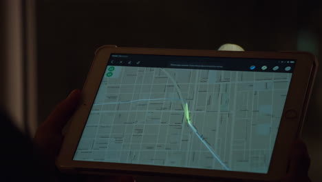 person using a tablet for map navigation at night