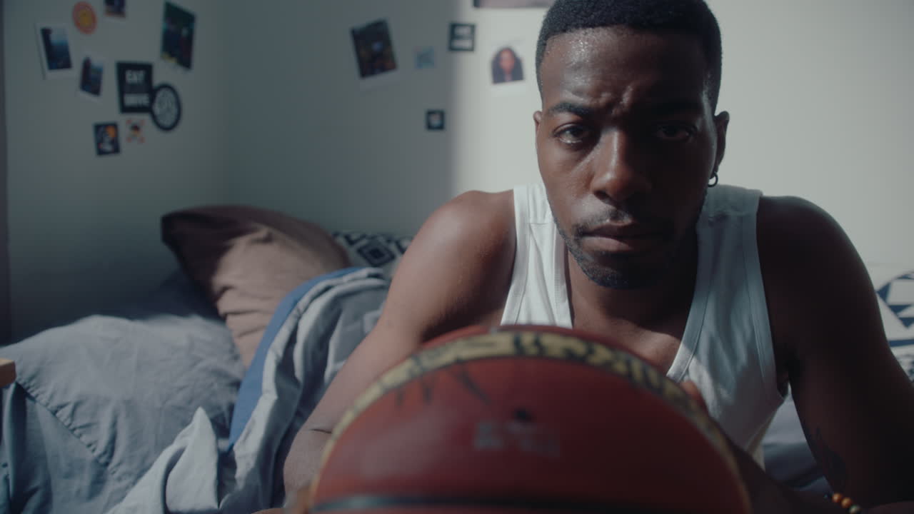 Black Man with Basketball Posing for Camera at Home