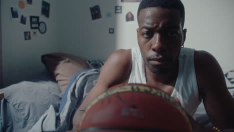 black man with basketball posing for camera at home