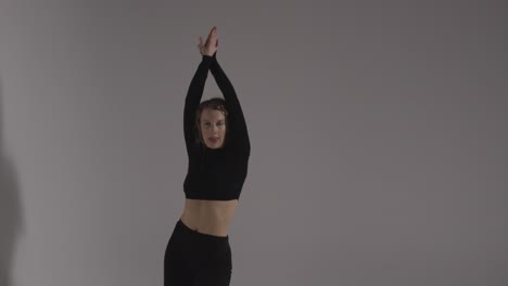 Foto-De-Estudio-De-Tres-Cuartos-De-Duración-De-Una-Mujer-Joven-Haciendo-Práctica-De-Baile-Contra-Un-Fondo-Gris-1