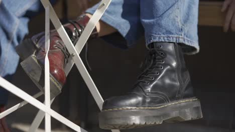 Young-women-in-stylish-leather-black-boots-grinder-in-jeans