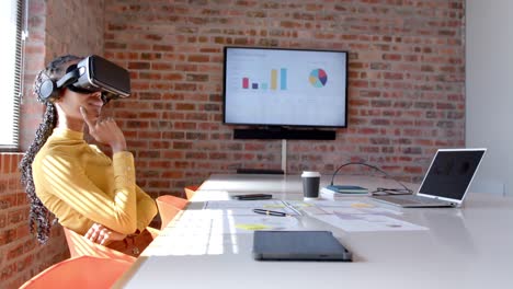 Happy-african-american-casual-businesswoman-using-vr-headset-in-sunny-meeting-room,-slow-motion