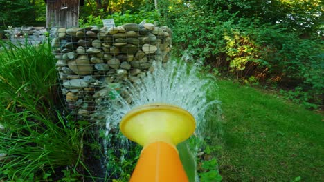 POV shot of a watering can pouring plants in a garden to grow vegetables or fruits