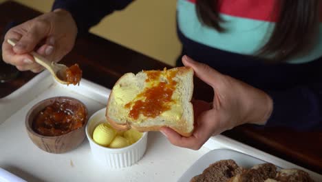 mermelada de melocotón casera esparcida sobre tostadas y mantequilla