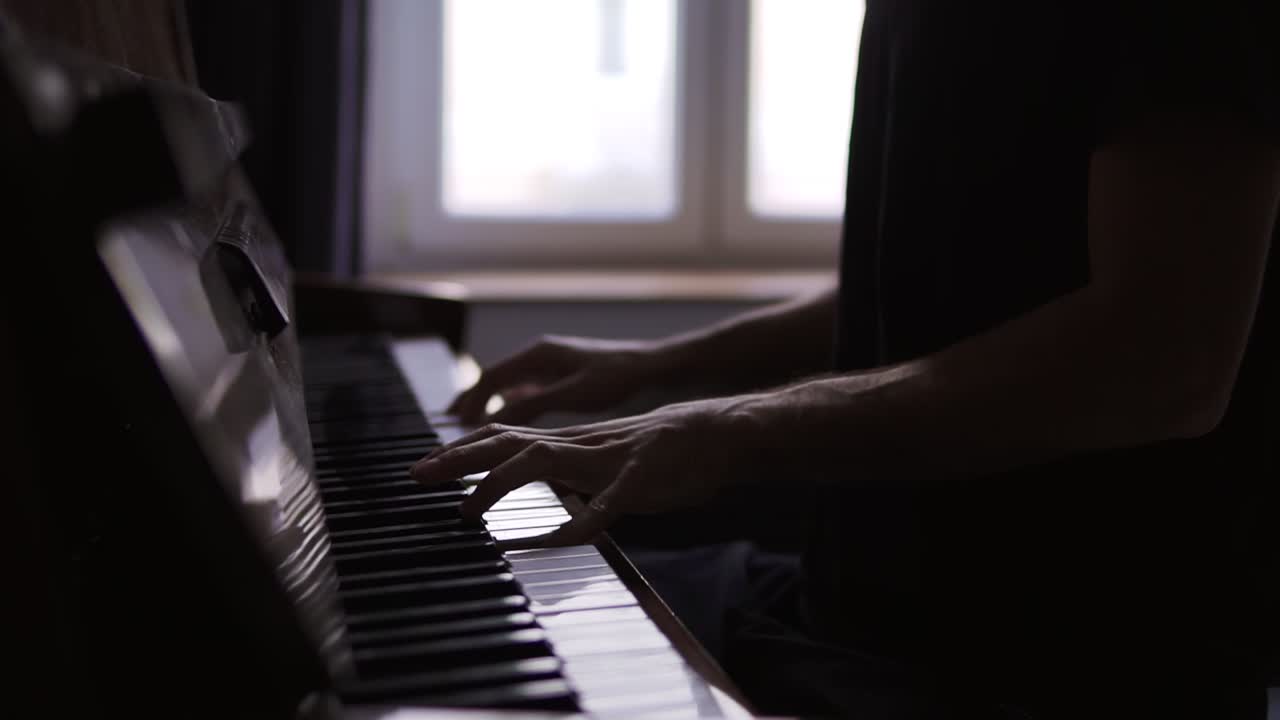 Close-up of pianist's hands practicing to play the piano at home