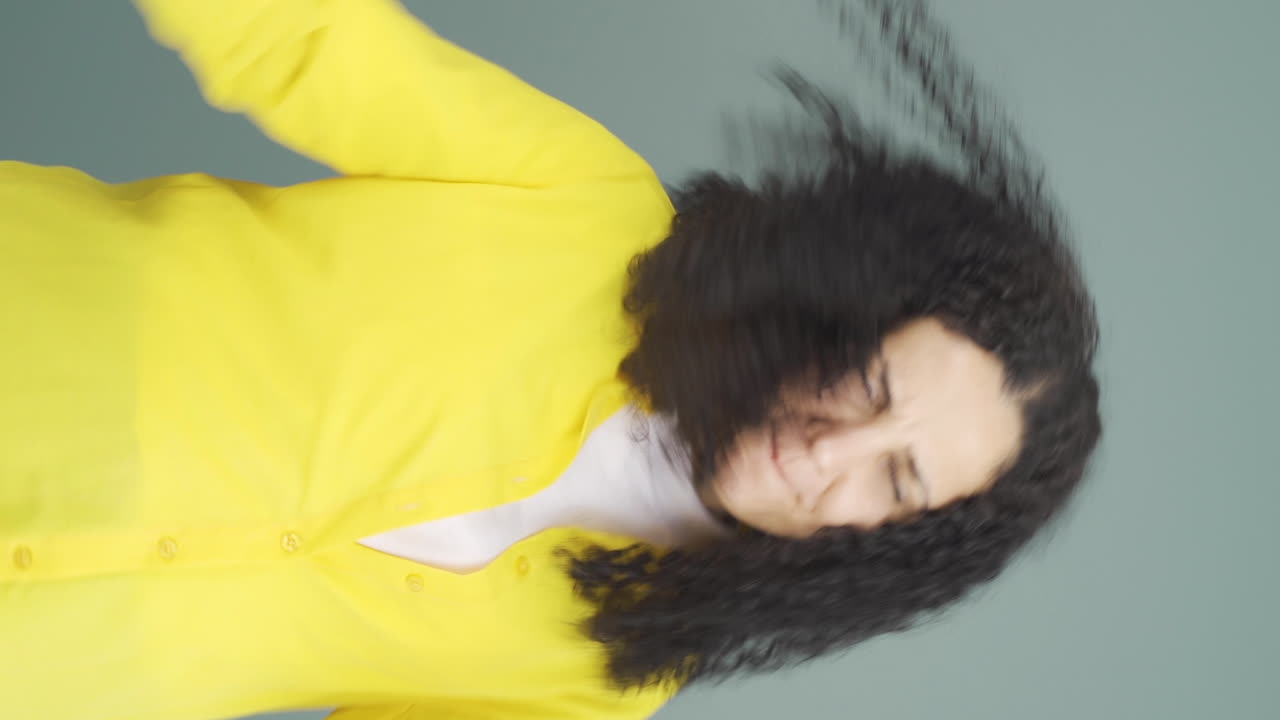 로커 표시와 춤을 추는 젊은 여성의 수직 비디오.