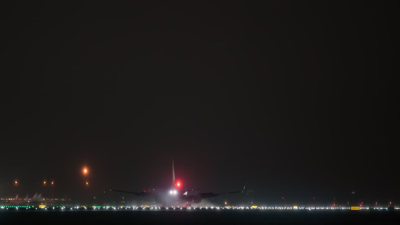 Atterraggio notturno di un aereo di linea commerciale su una pista illuminata