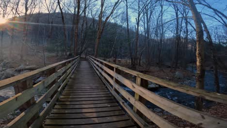 crossing a pedestrian wooden footbridge over a beautiful stream in the appalachian mountains