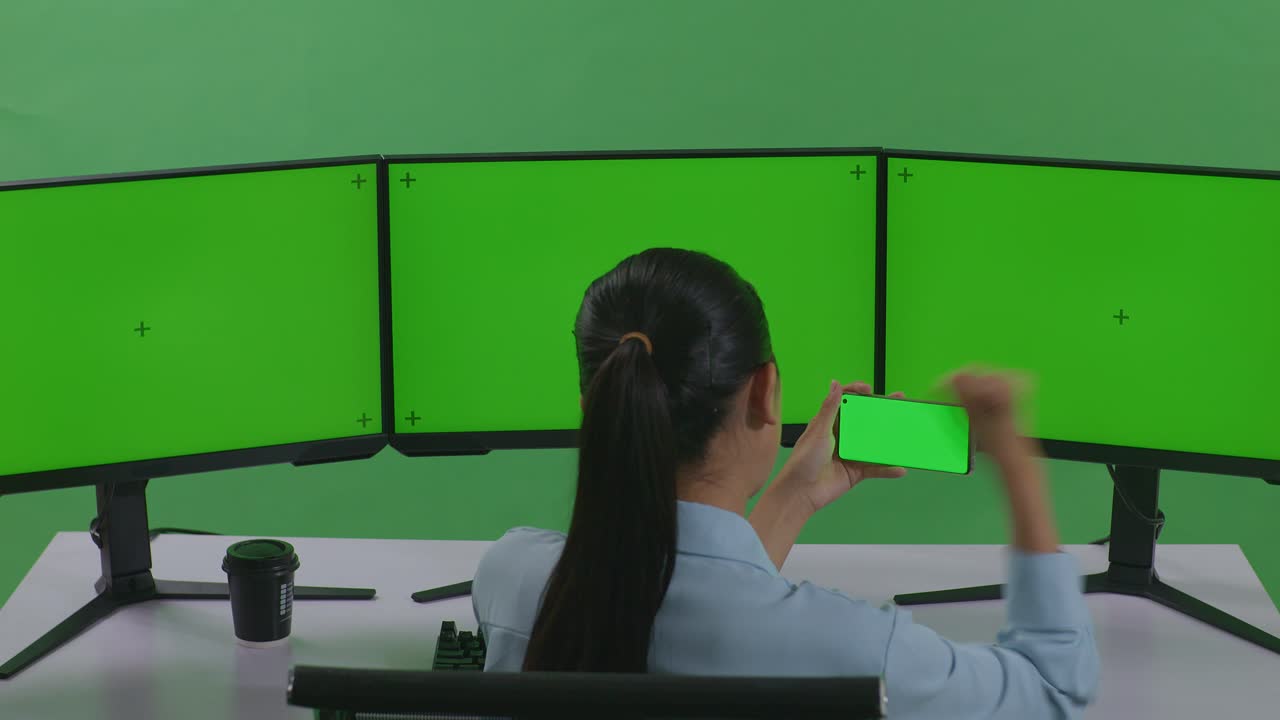 녹색 스크린 모니터 앞에서 성공을 축하하는 여성