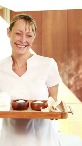 smiling masseuse holding a tray