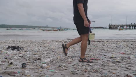 man walking through plastic-covered beach