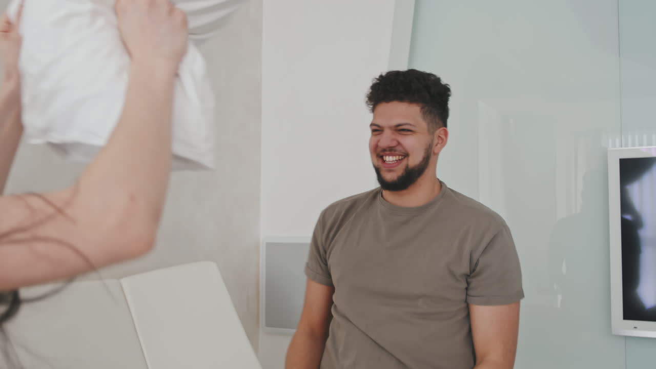 Cheerful Latin Couple During Pillow Fight