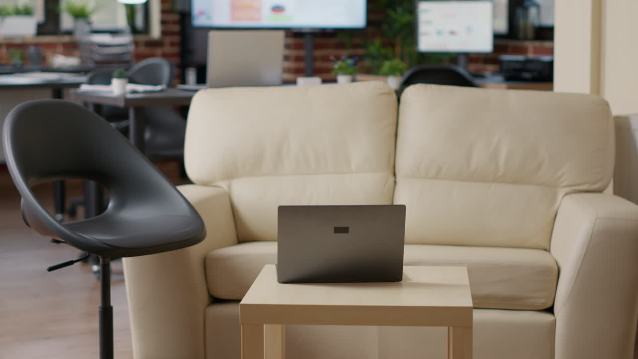 Empty startup office with couch and laptop computer
