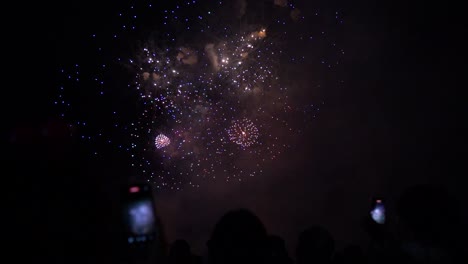 Beautiful-night-sky-being-illuminated-by-bright-exploding-fireworks