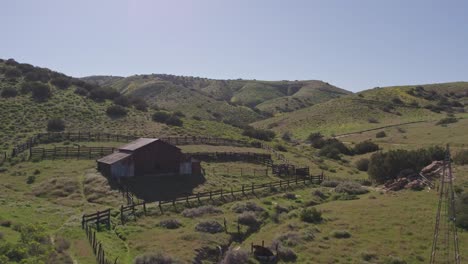 Aerial-Establishing-Shot-of-Abandoned-Barn-in-the-Green-Hills-of-Carrizo-Plain-in-California