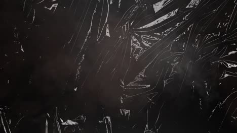 animation of fire and smoke over light on moving shiny black plastic