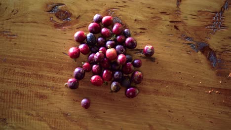 primer plano de granos de café de bayas rojas maduras en la mesa de madera