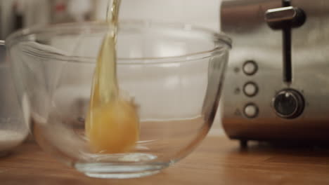 cracking eggs into measuring bowl, dolly slow motion