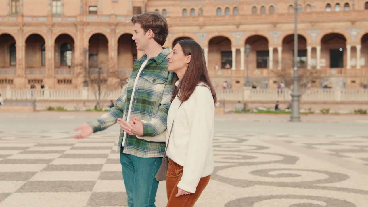 Jovens e apaixonados, um homem e uma mulher caminhando na praça de uma antiga cidade europeia