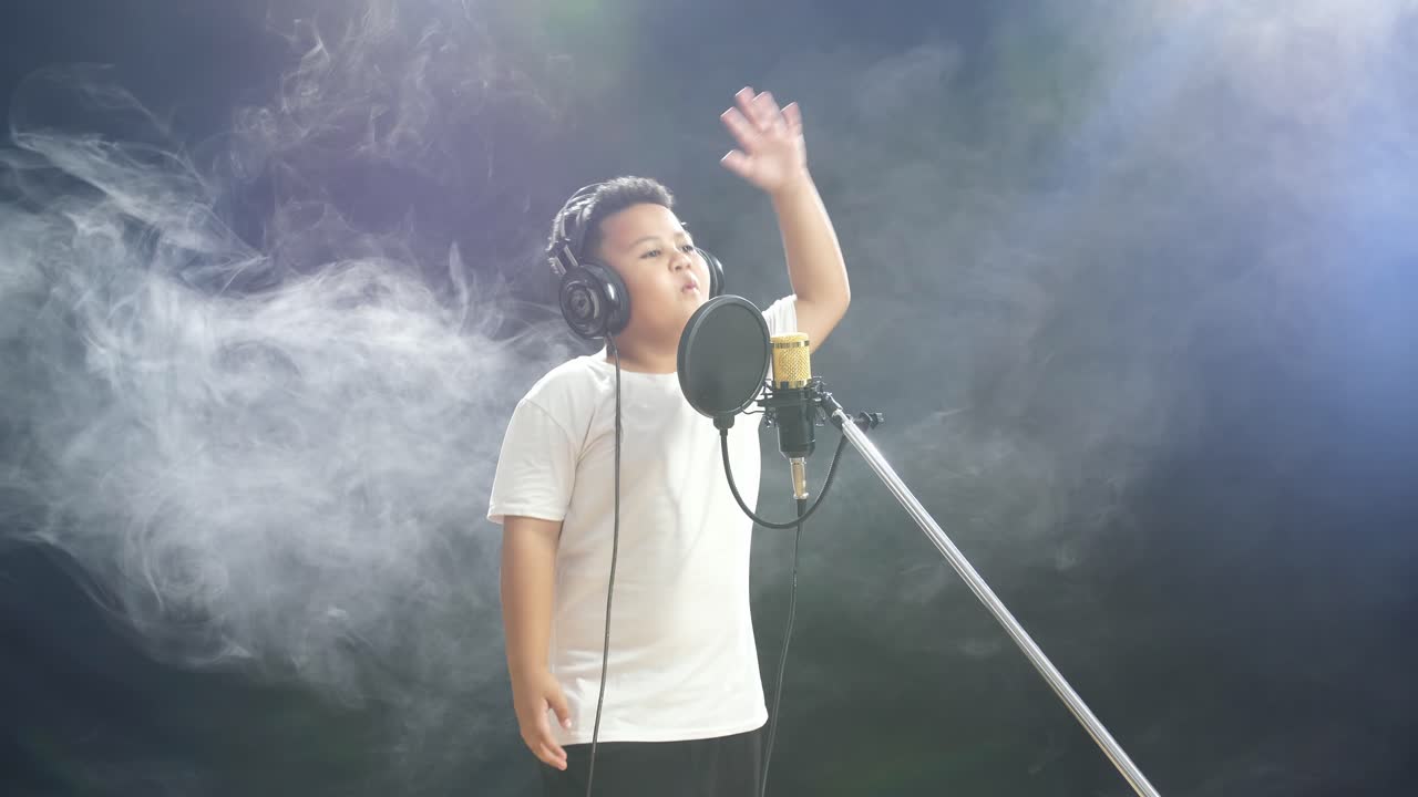 녹음 스튜디오 에서 마이크 로 노래 하는 어린 소년