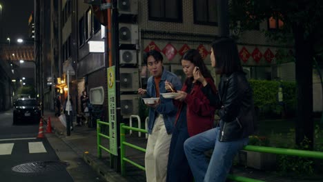 friends enjoying dinner at night in japan