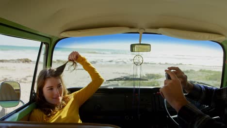 hombre joven haciendo clic en foto de mujer en furgoneta 4k