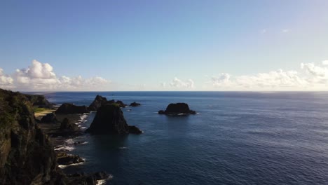 Large-rocky-structures-jutting-out-of-water-near-seashore-of-pacific-island