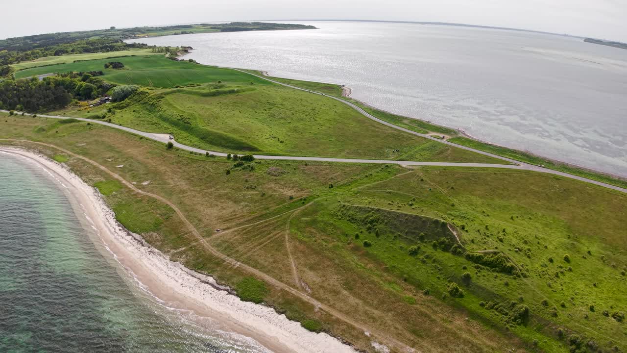 Aerial view of Dragsmur, the narrow land strip once used by Vikings to drag ships between seas, bordered by green fields and coastal waters