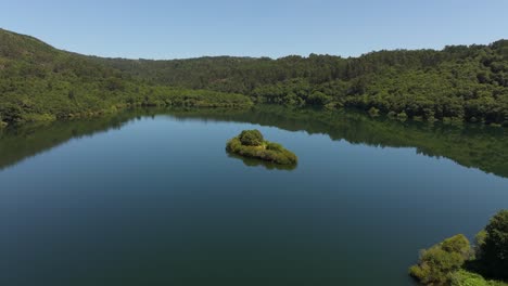 pequeña isla en las tranquilas aguas del río oitaven cerca de encoro de eiras en pontevedra, españa