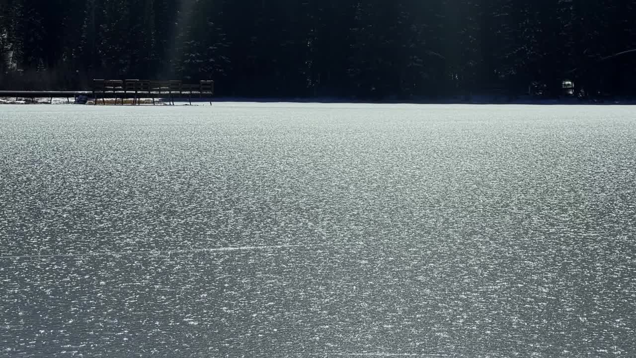 얼어붙은 실버 레이크 (silver lake) 의 천천히 움직이는 드, 유타 주 브라이튼의 유명한 스키 타운에서 나무로 된 보드워크와 소나무를 드러내는 빛 따뜻한 겨울 날.