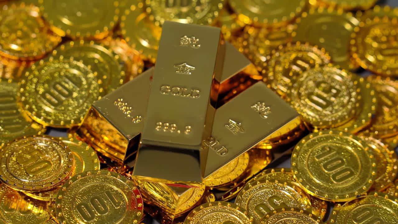 Zlaté cihly a ingoty ležící na hromadě naskládaných zlatých mincí odrážejí finanční prosperitu, úspory, investiční strategie, hromadění bohatství, ekonomickou hojnost a zajištěné spořicí plány. Tradiční.