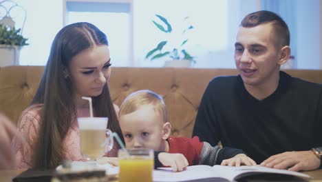 waiter-brings-chockolate-cake-slice-to-happy-family