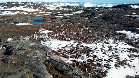 Espectacular-Vista-Aérea-Sobre-Cruces-Blancas,-Lápidas-En-Un-Pequeño-Cementerio-Hasta-La-Bahía-De-Icebergs-Derritiéndose