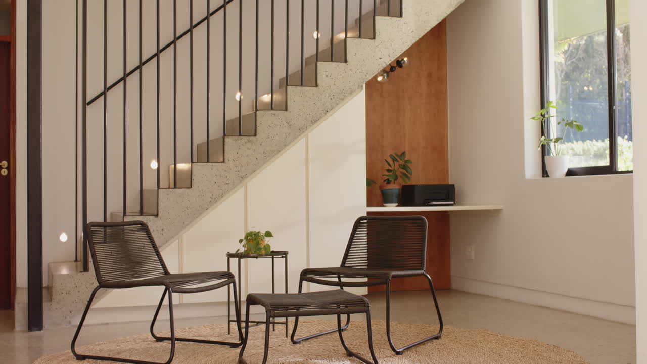 Modern living room with minimalist furniture and indoor plants under staircase, copy space