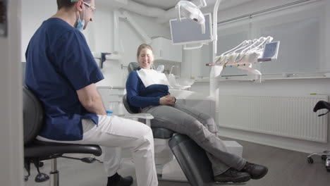 male dentist talking to female dental patient after oral examination, slider