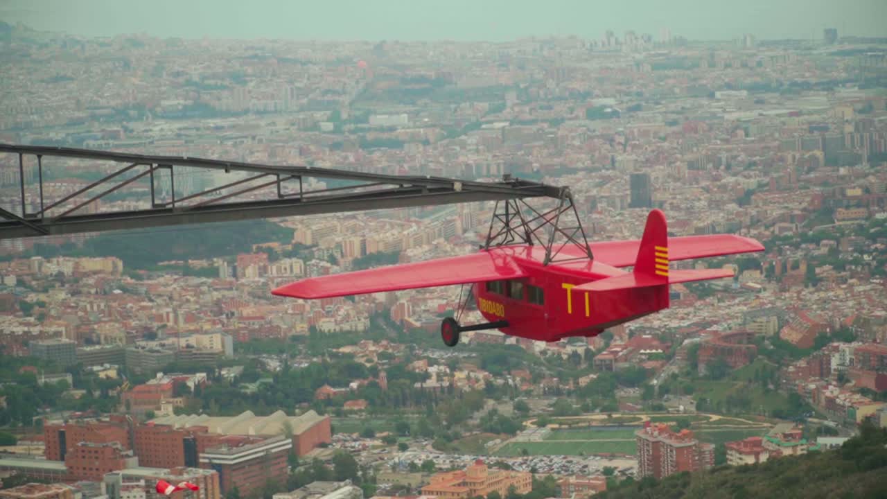 video impresionante de un planeador rojo girando lentamente en el aire, ofreciendo vistas panorámicas de barcelona