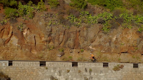 With-a-solitary-road-ahead,-a-man-rides-his-road-bike-in-the-morning,-immersing-himself-in-outdoor-exercise.-The-slow-motion-recording-conveys-the-excitement-of-extreme-sports