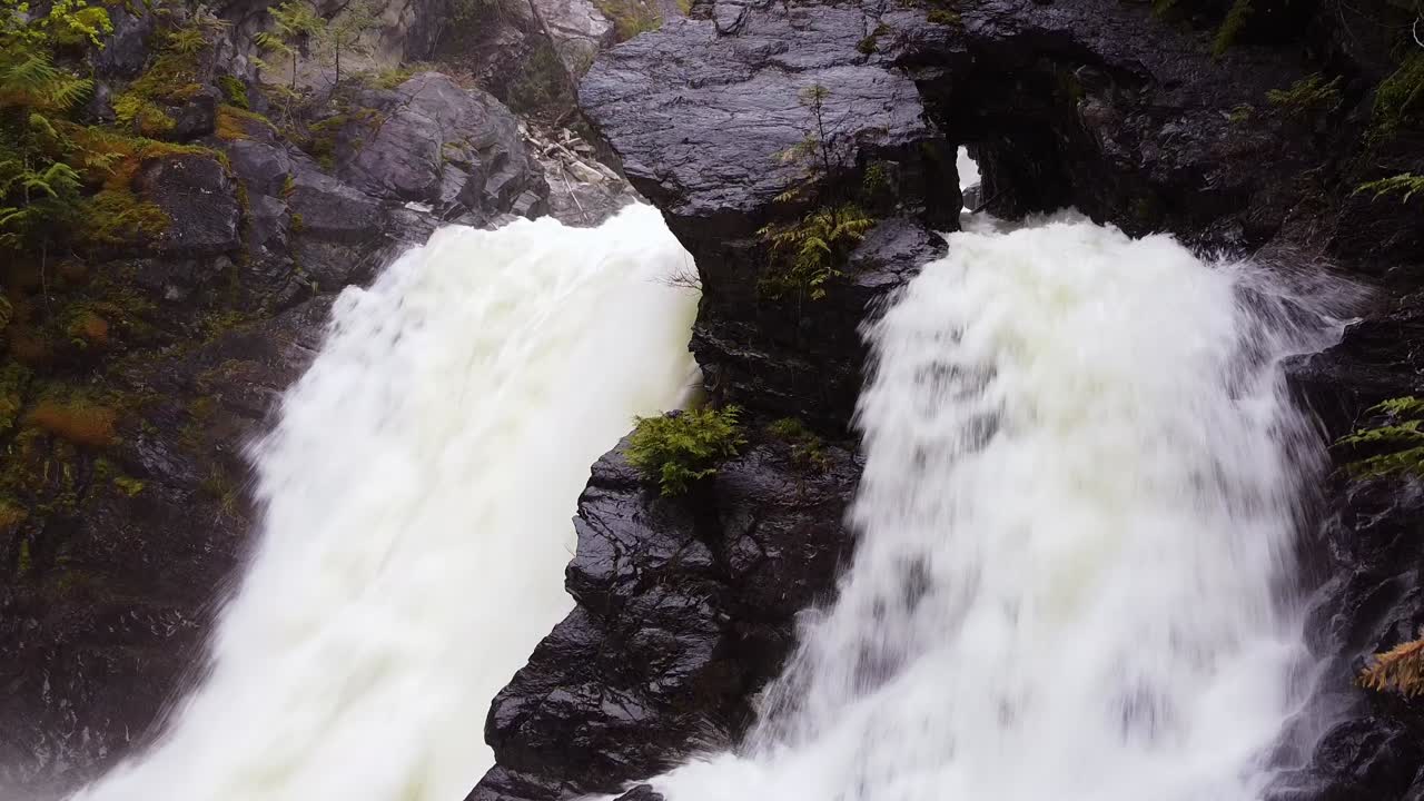 cascada de doble cara filmada en primavera con movimiento de cámara hacia abajo