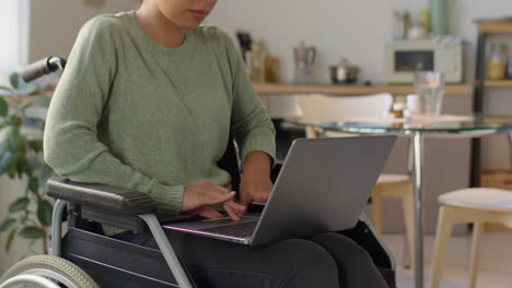 woman in wheelchair working on laptop at home