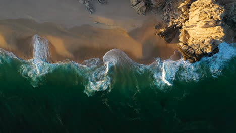 cinematic downward angle drone shot of the waves and beautiful beaches in cabo san lucas mexico