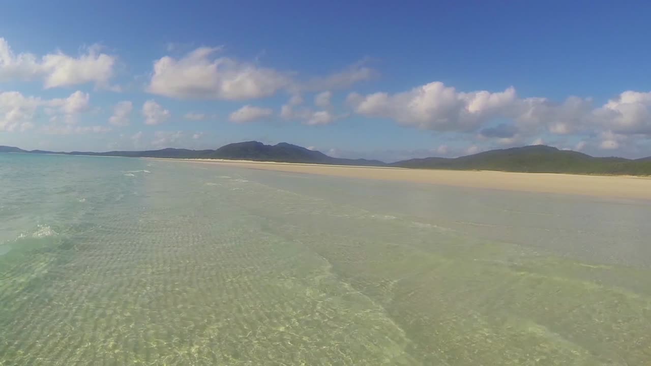 isla whitsunday en olas de cristal australiano que se desplazan lentamente hacia la playa de arena dorada.