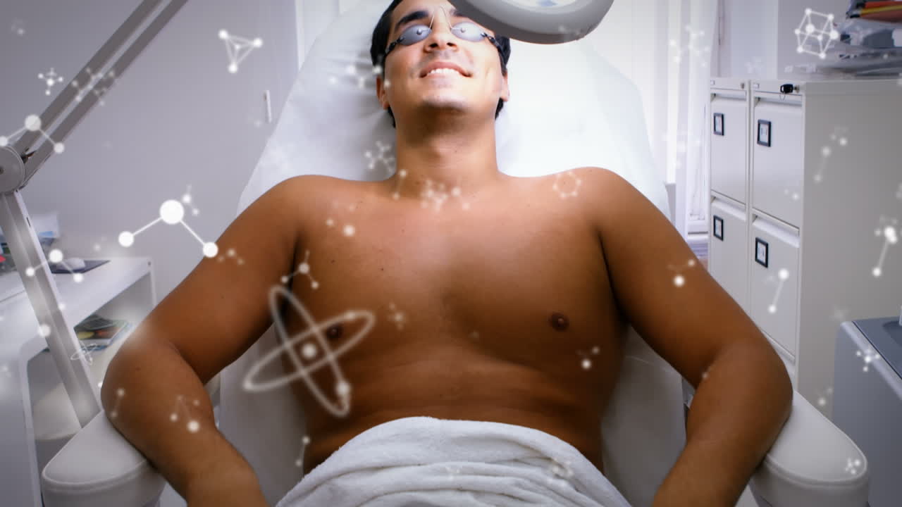 병원 침대에 누워 있는 두 인종의 남성 환자 위의 분자의 애니메이션