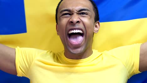 swedish fan celebrates holding the flag of sweden in slow motion