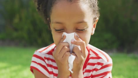 african american girl blowing her nose outside