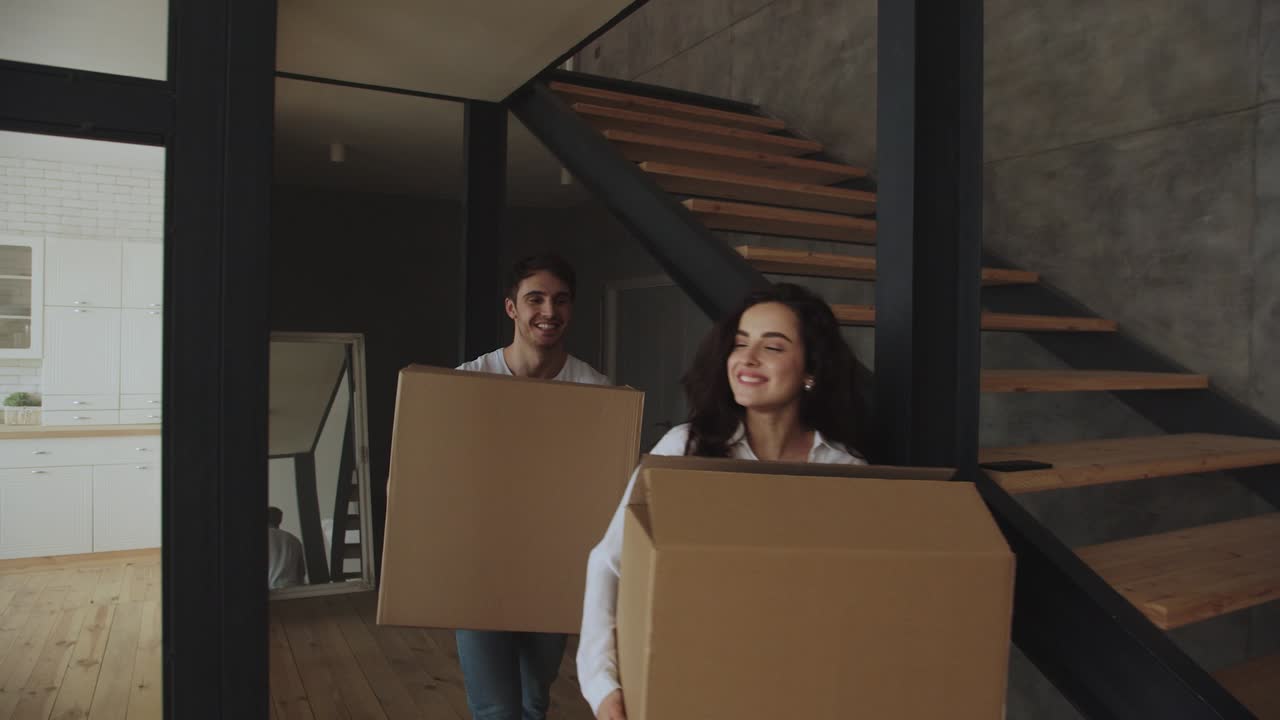una pareja feliz en primer plano con cajas moviéndose a una casa de lujo juntos.