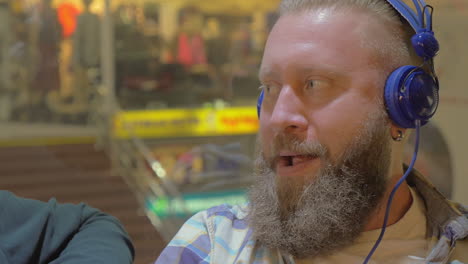 two men listening to music in shopping mall